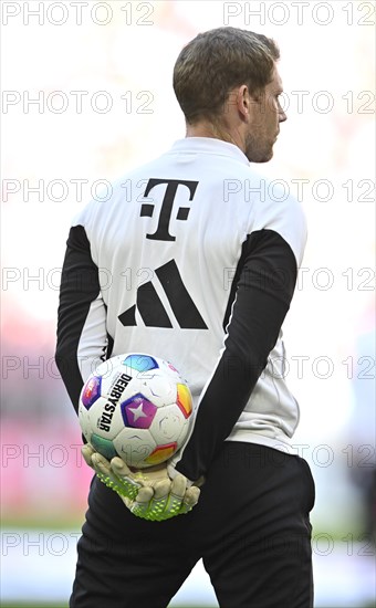 Goalkeeper coach Michael Rechner FC Bayern Munich FCB holds Adidas Derbystar match ball on his back, logo, Allianz Arena, Munich, Bavaria, Germany, Europe