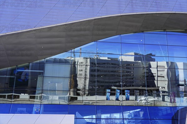Glass facade of a modern building that reflects the surrounding structures, BMW WELT, Munich, Germany, Europe