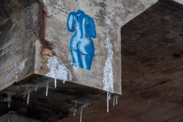 Blue graffiti of a female torso on concrete with icicles, urban street art in cold weather, Magdeburg, Saxony-Anhalt, Germany, Europe