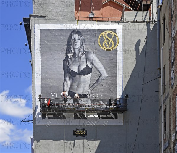 Painter on hanging scaffolding creating mural, advertisement with woman in bikini, SoHo neighbourhood, Manhattan, New York City, New York, USA, North America