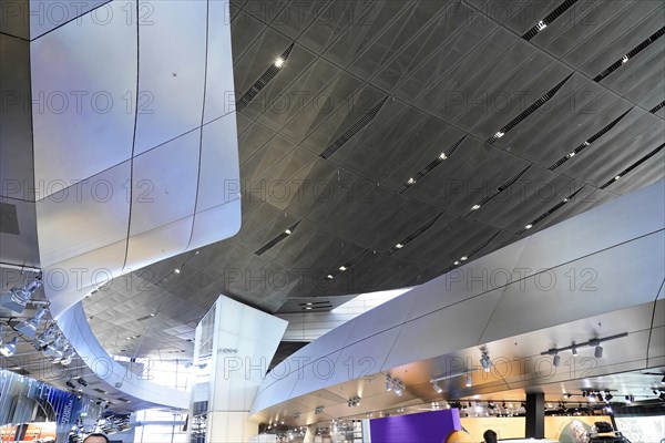 Interior view of a building with shiny ceilings and shops, BMW WELT, Munich, Germany, Europe