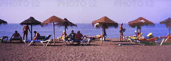 Sunbathers with parasols on the beach in Torre del Mar, Costa del Sol, Malaga province, Andalusia, Spain, Southern Europe. Scanned slide, Europe