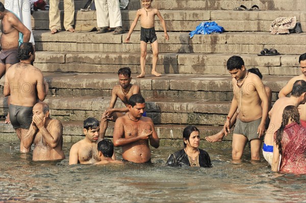 People taking a communal bath in the river, indicating social bonding, Varanasi, Uttar Pradesh, India, Asia