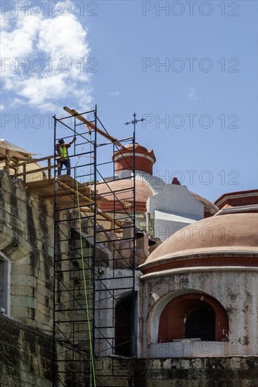 Oaxaca, Mexico, A worker on scaffolding repairing Guadalupe Church, Central America
