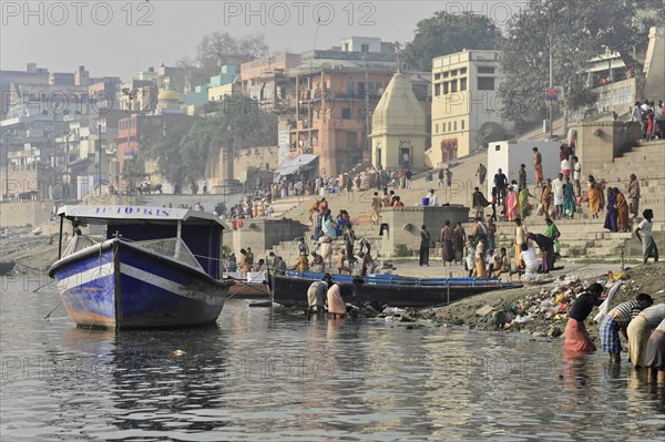 Boat on the riverbank with city view and people in everyday life, Varanasi, Uttar Pradesh, India, Asia