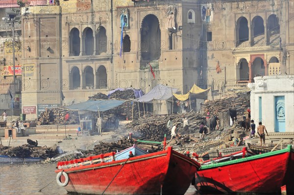 People going about their cultural activities at the smoke shrouded ghats of a river, Varanasi, Uttar Pradesh, India, Asia