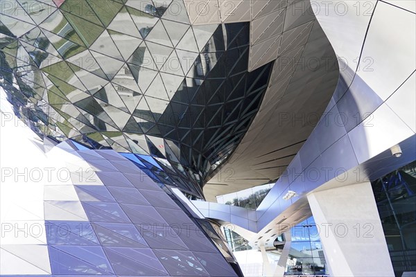 View of a complex glass shell of a building with fascinating reflections and shapes, BMW WELT, Munich, Germany, Europe