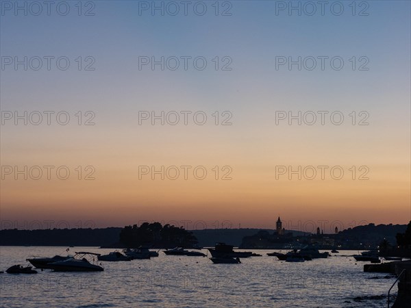 Boats anchoring in a bay, church towers, evening mood after sunset over Rab, town of Rab, island of Rab, Kvarner Gulf Bay, Croatia, Europe