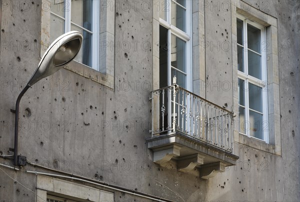 Contemporary history on a building in Berlin Mitte. A lantern from the GDR era on a building that shows clearly visible traces of the Second World War, 08/08/2018