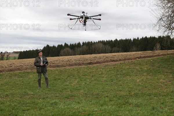 Hunter observes and controls flying drone during a hare (Lepus europaeus) census, Lower Austria, Austria, Europe