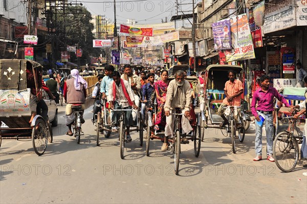 Lively street scene with cycle rickshaws and passers-by in a busy area, Varanasi, Uttar Pradesh, India, Asia