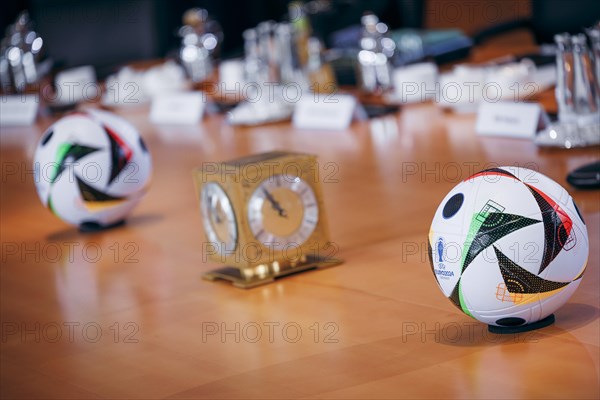 Two footballs lie on the cabinet table during a cabinet meeting at the Federal Chancellery in Berlin, 06/03/2024