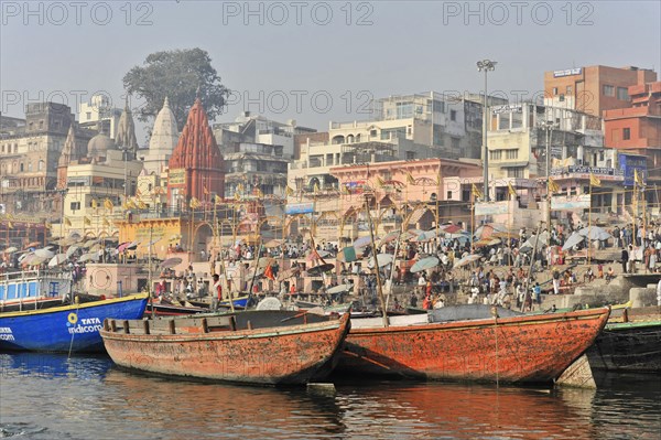 Lively riverside landscape with crowds of people and boats in the hazy background, Varanasi, Uttar Pradesh, India, Asia
