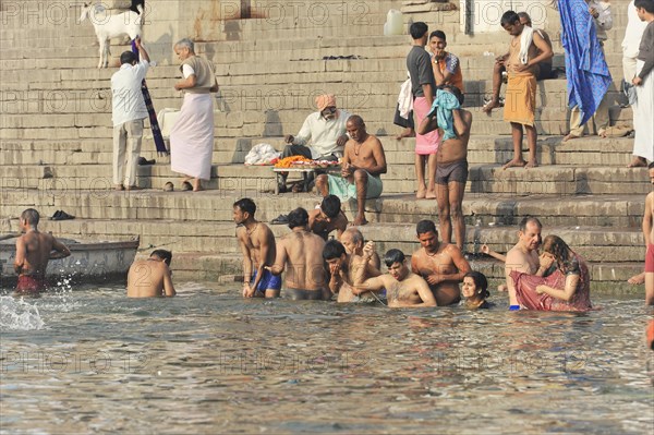 Group of people bathing and socialising in the water of a river, Varanasi, Uttar Pradesh, India, Asia