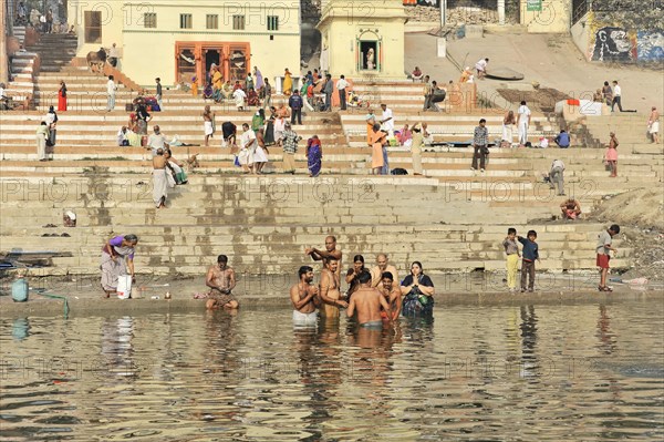 View of steps on riverbank with people performing daily ritual, Varanasi, Uttar Pradesh, India, Asia