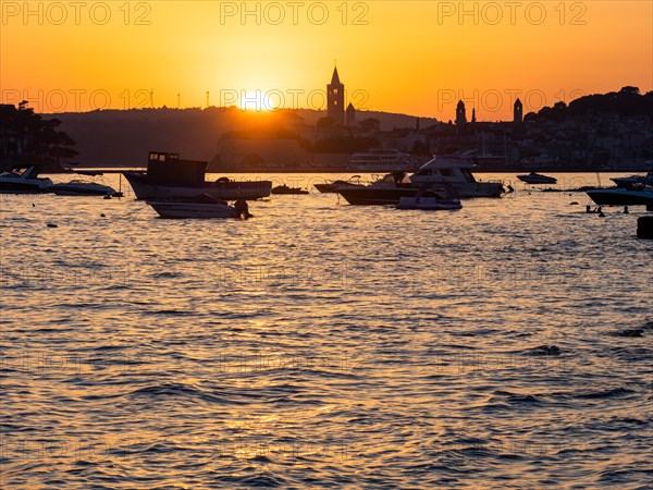 Boats anchoring in a bay, silhouette of a church tower, sunset over Rab, town of Rab, island of Rab, Kvarner Gulf Bay, Croatia, Europe