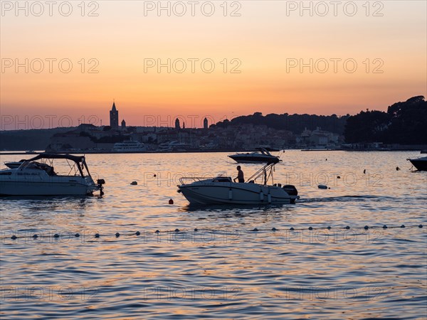 Boats anchoring in a bay, church towers, evening mood after sunset over Rab, town of Rab, island of Rab, Kvarner Gulf Bay, Croatia, Europe