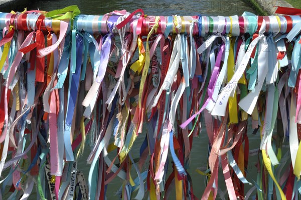 Vibrant colorful ribbons tied to a bridge's railing over water, representing a festive or cultural tradition, Aveiro, canal, portugal, tour tourism, bridge, outdoors, river, aveiro, colourful, no people, sightseeing, color image, famous place, multi colored, aveiro city, aveiro district, bridge, built structure, ribbon, sewing item