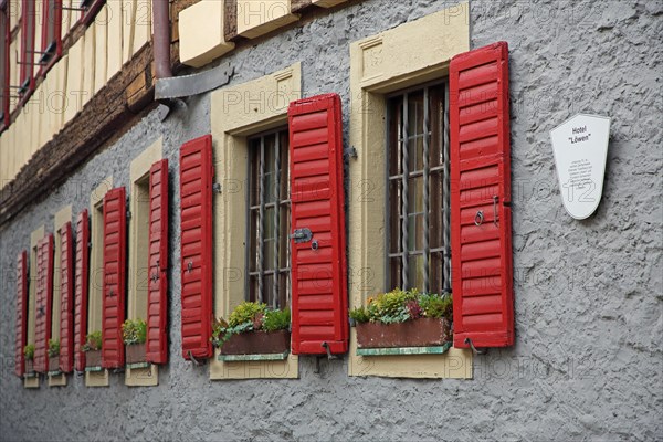 Row of red shutters on the Hotel Loewen, bars, bars, metal bars, shutter, house wall, red, window, detail, Marktbreit, Lower Franconia, Franconia, Bavaria, Germany, Europe