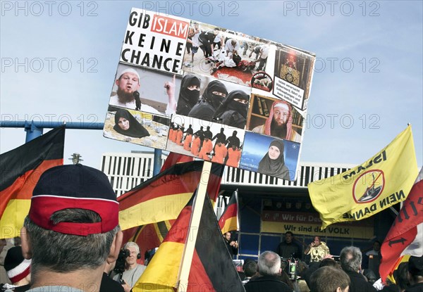A participant in the Merkel muss weg demonstration holds a sign reading Gib Islam keine Chance. Demonstration by right-wing populist and right-wing extremist participants, including supporters of the NPD, Pegida, Reichsbuerger, hooligans, Landsmannschaften and Identitarians, Berlin, 4 March 2017