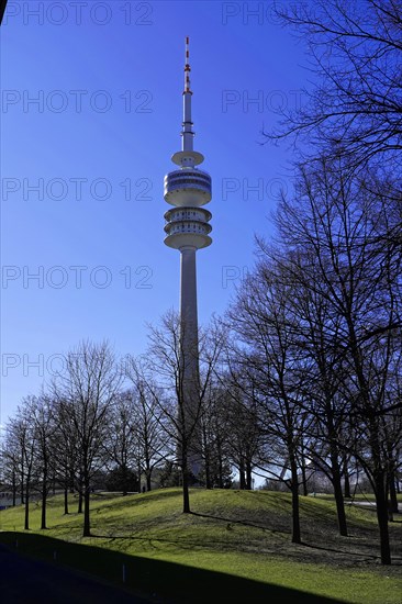 TV tower rises behind bare trees against a clear blue sky, BMW WELT, Munich, Germany, Europe