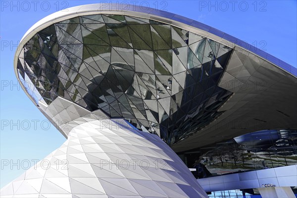 A modern building with a reflective glass facade under a clear blue sky, BMW WELT, Munich, Germany, Europe