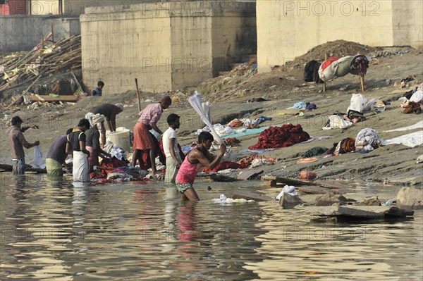 People washing and spreading clothes on the bank of a river, everyday scene with labour activity, Varanasi, Uttar Pradesh, India, Asia