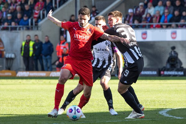 Football match, Tim KLEINDIENST 1.FC Heidenheim fighting for the ball with captain Julian WEIGL Borussia Moenchengladbach at the back and Maximilian WOeBER Borussia Moenchengladbach on the right, Voith-Arena football stadium, Heidenheim