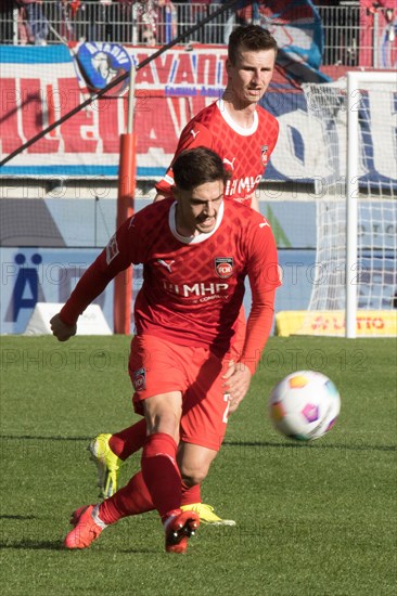 Football match, Nikola DOVEDAN 1.FC Heidenheim shooting in the background Jan SCHOePPNER 1.FC Heidenheim, football stadium Voith-Arena, Heidenheim