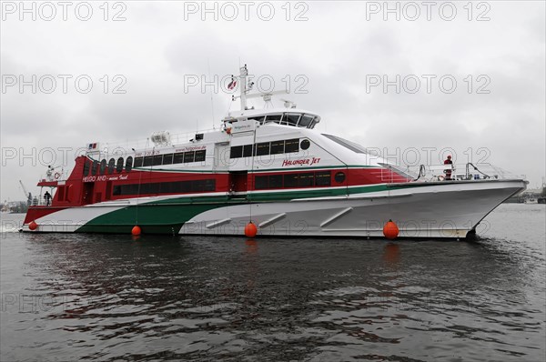 The red and white catamaran 'Halunder Jet' tied between two buoys on the water, Hamburg, Hanseatic City of Hamburg, Germany, Europe