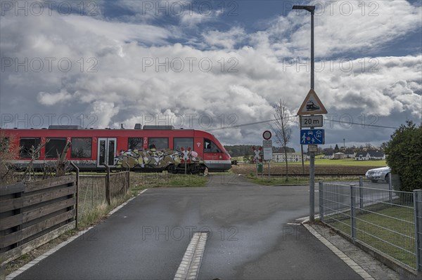 Suburban railway crossing an ungated level crossing in a village, Forth, Middle Franconia, Bavaria, Germany, Europe