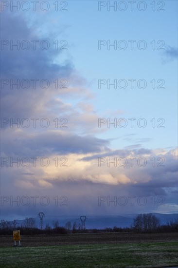 Weather change with mighty light to grey-blue clouds illuminated by the evening sun over the Black Forest as seen from Algolsheim, Haut-Rhin, Grand Est, France, Europe