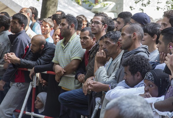 Refugees from Syria wait behind barriers in the central reception centre for asylum seekers at the State Office for Health and Social Affairs in Berlin, 26/08/2015