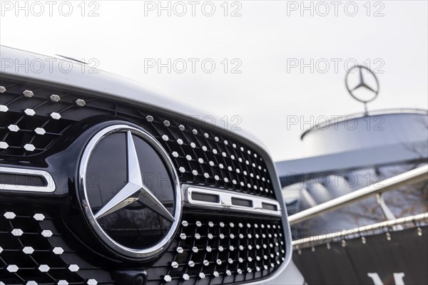 Mercedes, radiator grille and Mercedes star on a modern vehicle, in the background the Mercedes Benz World, customer centre and car dealership in Bad Cannstatt, Baden-Wuerttemberg, Germany, Europe