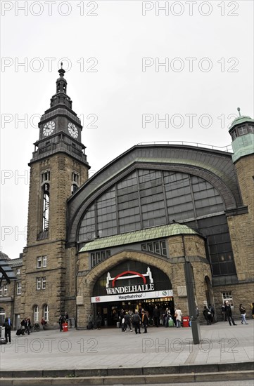 Historic railway station with tower clock and people walking past the entrance, Hamburg, Hanseatic City of Hamburg, Germany, Europe