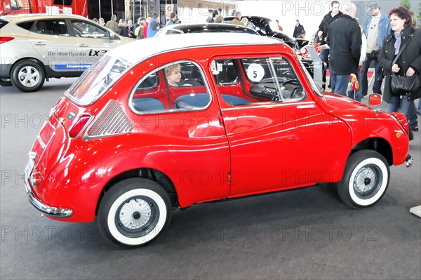 A small red vintage Subaru 360 with a white roof in an exhibition hall, Stuttgart Trade Fair Centre, Stuttgart, Baden-Wuerttemberg, Germany, Europe