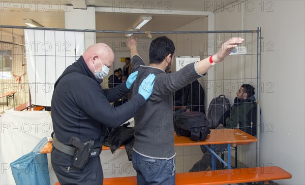 Refugees are searched by federal police officers after their arrival at Rosenheim station, 05/02/2016