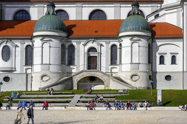 Spring awakening, people sunbathing in front of the Lorenzkirche, Kempten, Allgaeu, Bavaria, Germany, Europe
