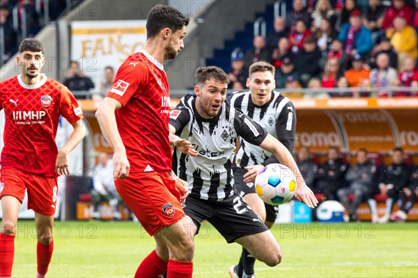 Football match, Tim KLEINDIENST 1.FC Heidenheim in the centre fighting for the ball with Joe SCALLY Borussia Moenchengladbach and Maximilian WOeBER Borussia Moenchengladbach right in the background left Eren DINKCI 1.FC Heidenheim, football stadium Voith-Arena, Heidenheim