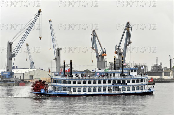 A classic paddle steamer sails past harbour cranes, accompanied by a slightly cloudy sky, Hamburg, Hanseatic City of Hamburg, Germany, Europe