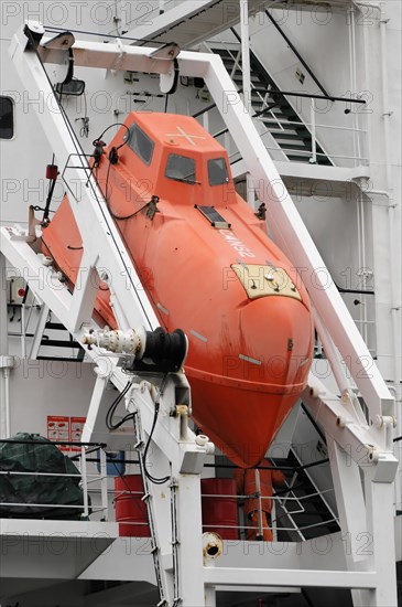 Red lifeboat suspended from a white ship in the harbour, Hamburg, Hanseatic City of Hamburg, Germany, Europe