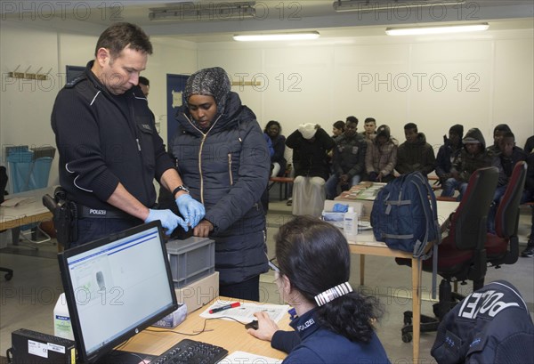 Refugees are registered and recorded by the Federal Police in Rosenheim. A Federal Police officer takes a fingerprint scan, 05/02/2016