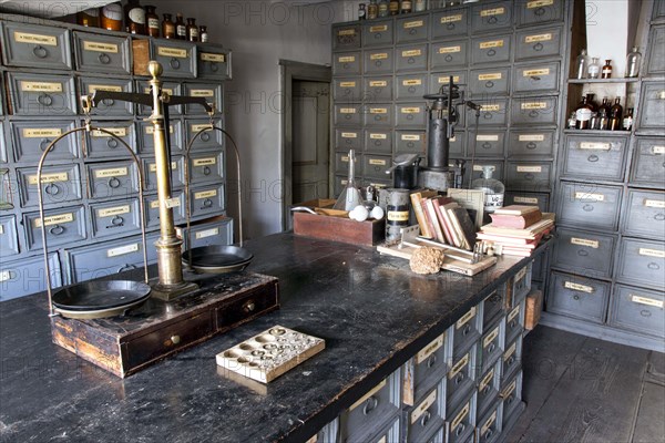 A pharmacist's scales stand on a worktable in front of shelves with drawers containing ingredients for the production of medicines in the former laboratory of the historic Berg Pharmacy in Clausthal-Zellerfeld. The current Berg-Apotheke, one of the oldest pharmacies in Germany, was built in 1674, 09.11.2015