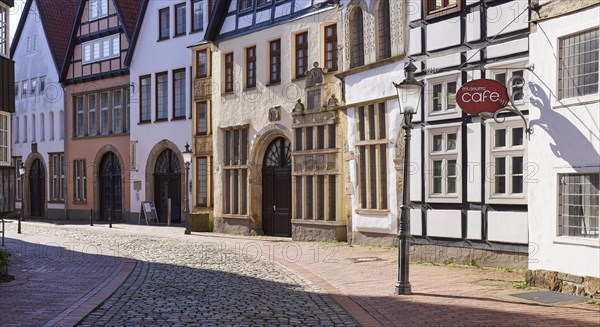 Historic facades, lantern and sign for the cafe with backlight in the Schnurrviertel in the old town of Minden, Muehlenkreis Minden-Luebbecke, North Rhine-Westphalia, Germany, Europe