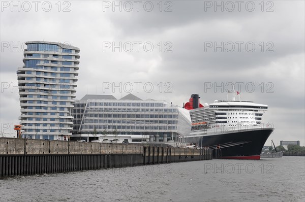 A Queen Mary 2 cruise ship moored in the harbour next to modern waterfront buildings, Hamburg, Hanseatic City of Hamburg, Germany, Europe