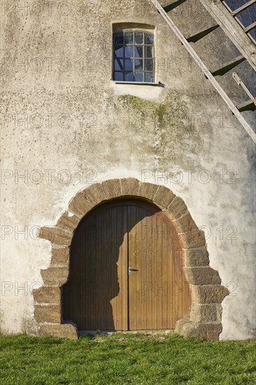 Entrance gate, window and part of the wings of the windmill Auf der Hoechte under a cloudless blue sky in Hille, Muehlenkreis Minden-Luebbecke, North Rhine-Westphalia, Germany, Europe