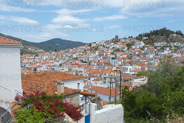 View of a picturesque village with white houses and red roofs under a cloudy sky, Poros, Poros Island, Saronic Islands, Peloponnese, Greece, Europe