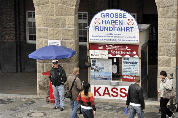 People standing in front of a kiosk for harbour tours in an urban environment, Hamburg, Hanseatic City of Hamburg, Germany, Europe