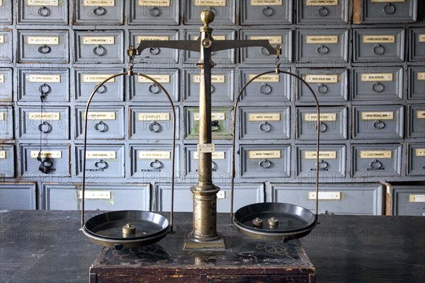 A pharmacist's scales stand on a worktable in front of shelves with drawers containing ingredients for the production of medicines in the former laboratory of the historic Berg Pharmacy in Clausthal-Zellerfeld. The current Berg-Apotheke, one of the oldest pharmacies in Germany, was built in 1674, 09.11.2015