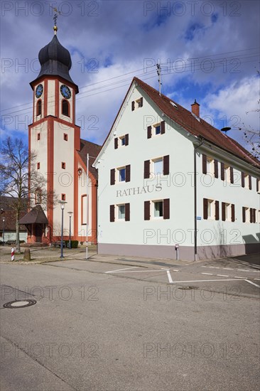 St John's Church and town hall under a blue sky with white cumulus clouds in Bad Krozingen, Breisgau-Hochschwarzwald district, Baden-Wuerttemberg, Germany, Europe